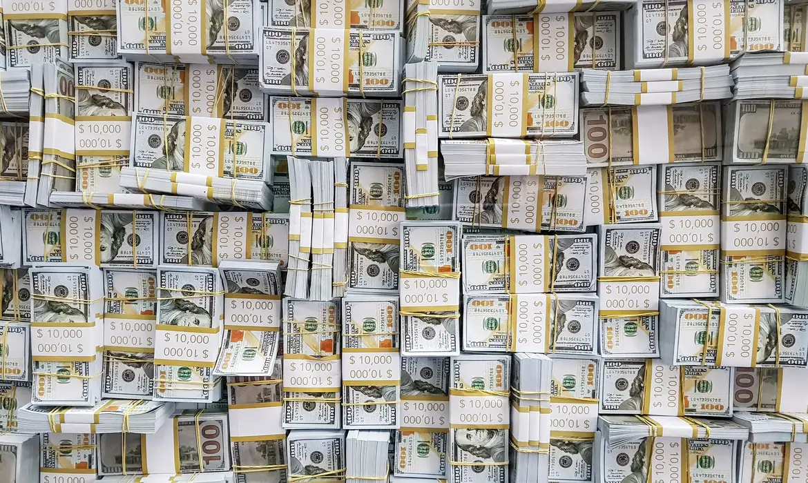 Notas de dólar e cifrões representando o câmbio e investimentos